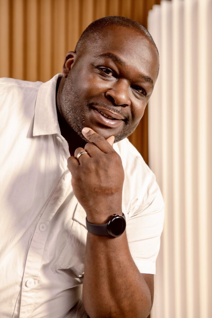 Portrait of Jeff Harris. A young black man wearing a white short sleeve button up.