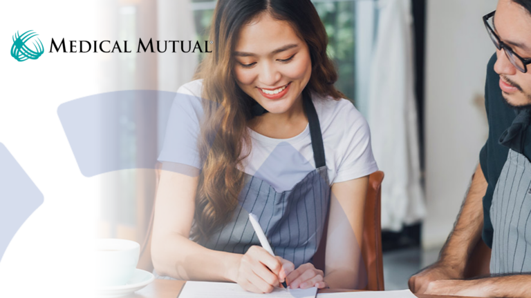 two business owners discussing their healthcare plan and writing on a notepad